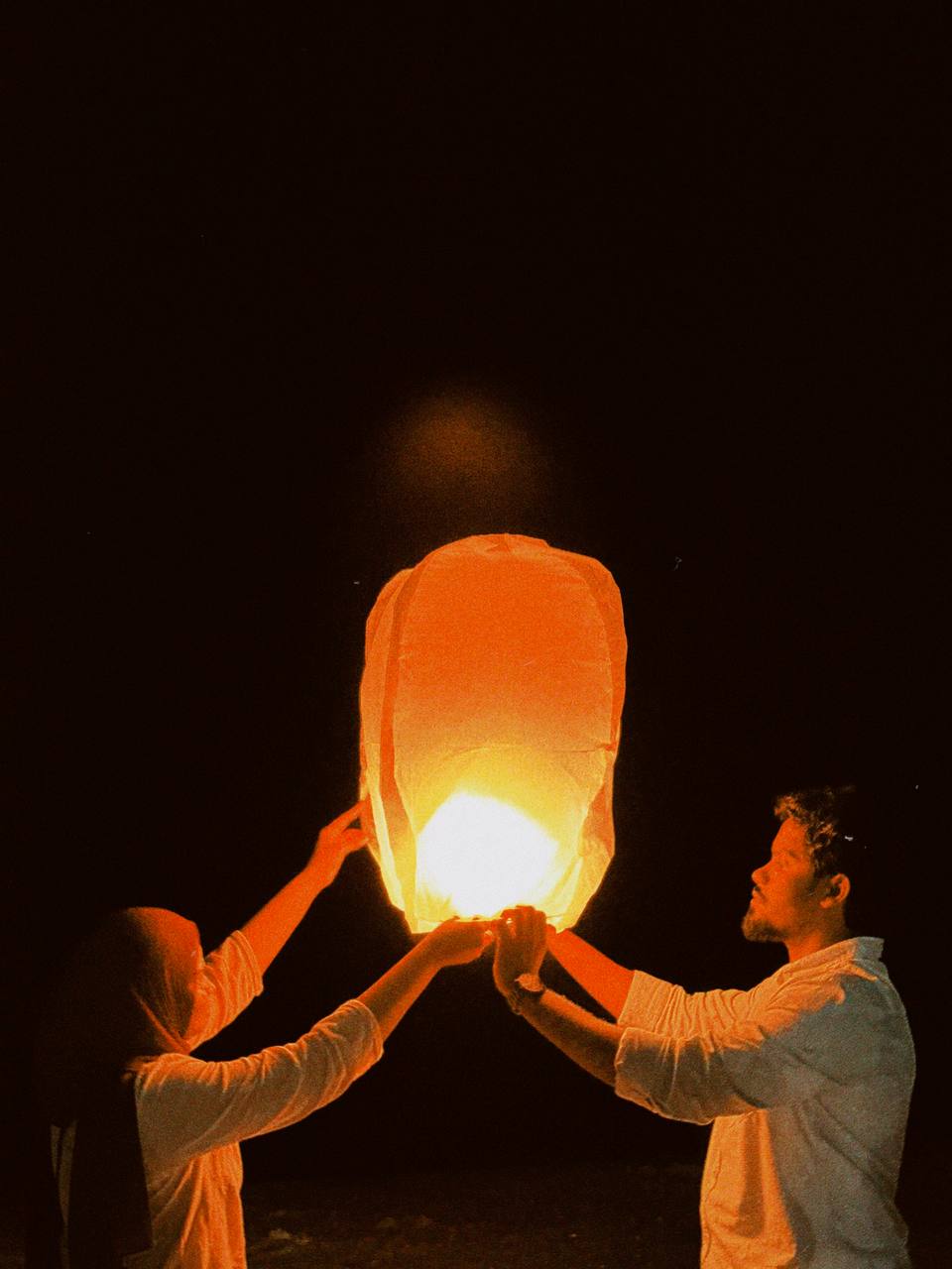 Munsif and Nahula holding a glowing sky lantern together